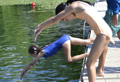 two kids diving into a lake