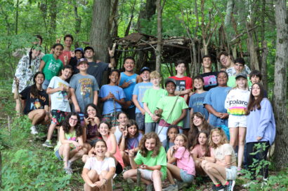 large group posing for a picture in the woods